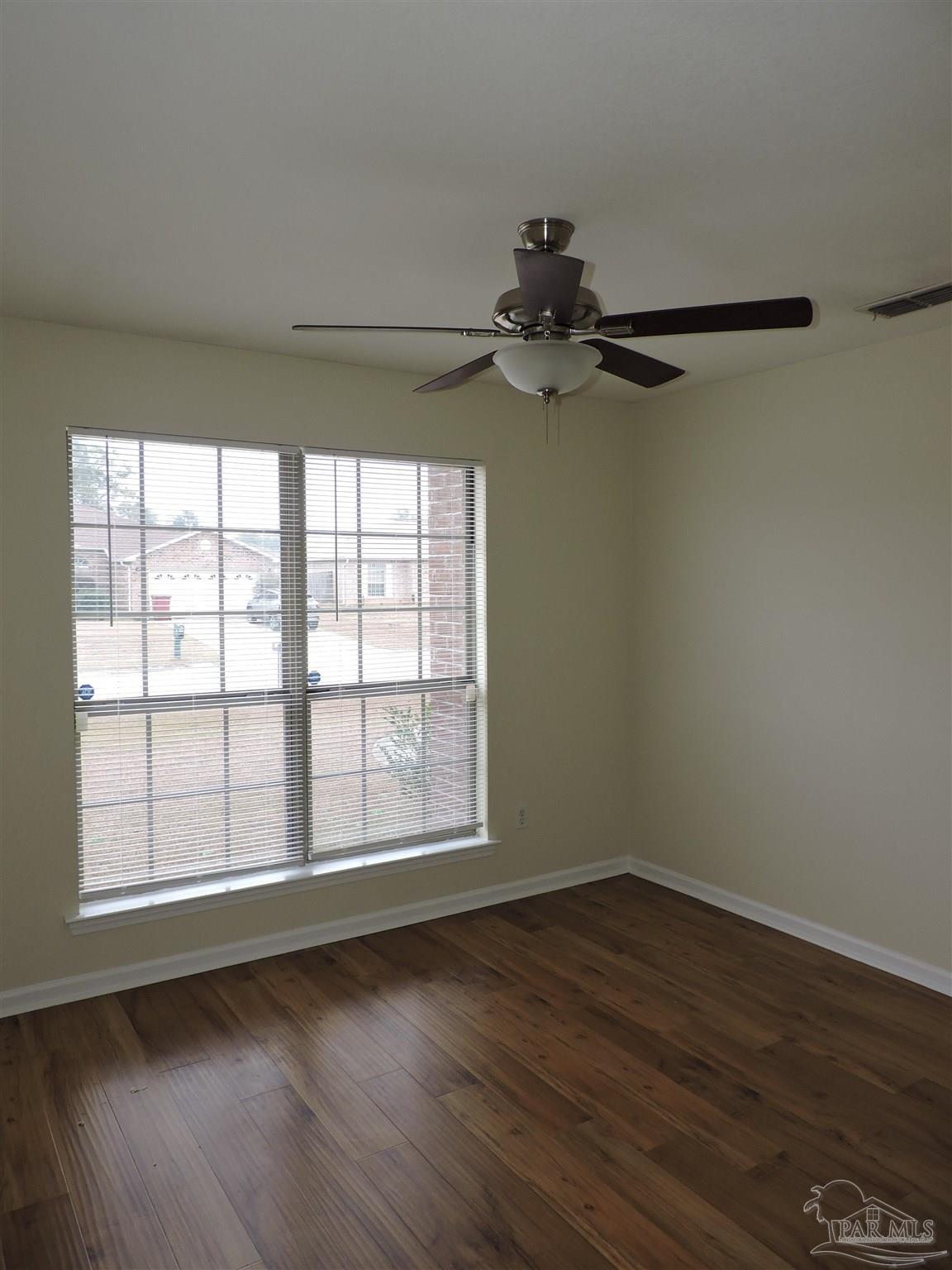 7070 Marissa Point Lane Milton, FL 32570 - Photo 13 of 21 a view of an empty room with wooden floor and a window