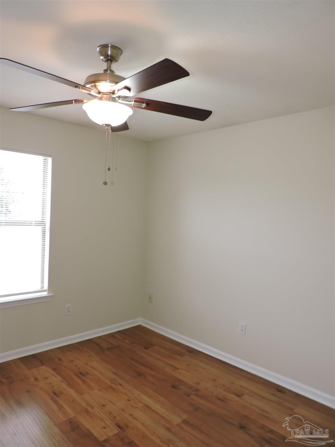 7070 Marissa Point Lane Milton, FL 32570 - Photo 19 of 21 a view of an empty room with wooden floor and a window