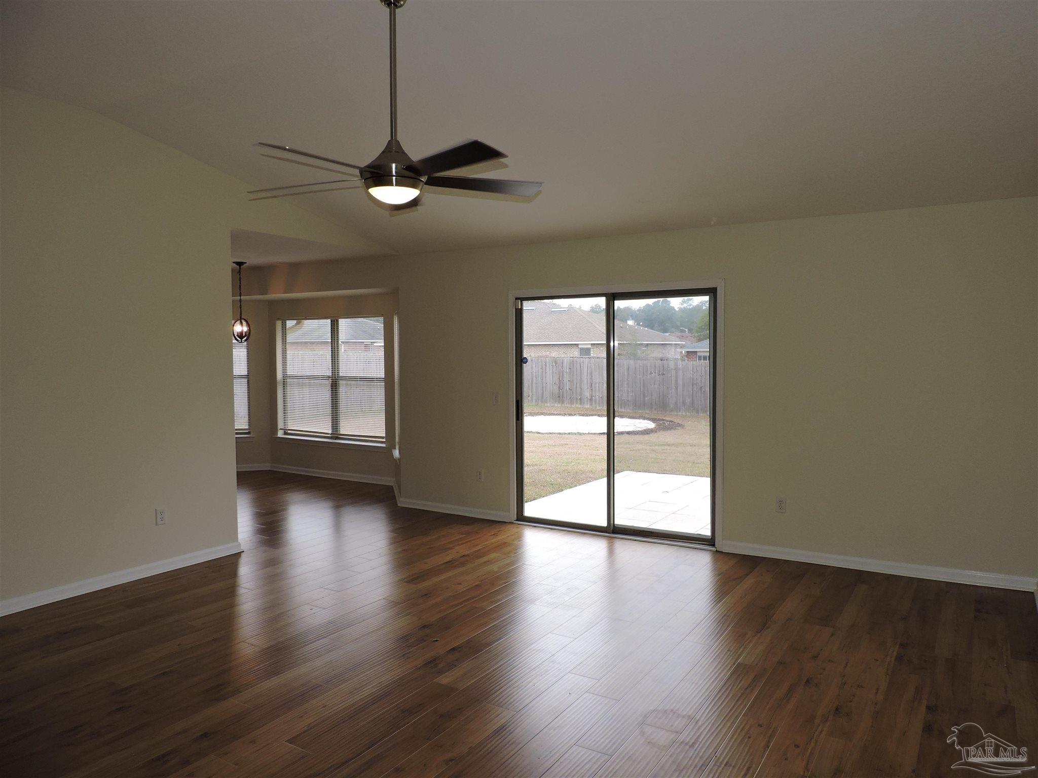 7070 Marissa Point Lane Milton, FL 32570 - Photo 3 of 21 a view of a livingroom with wooden floor and a ceiling fan