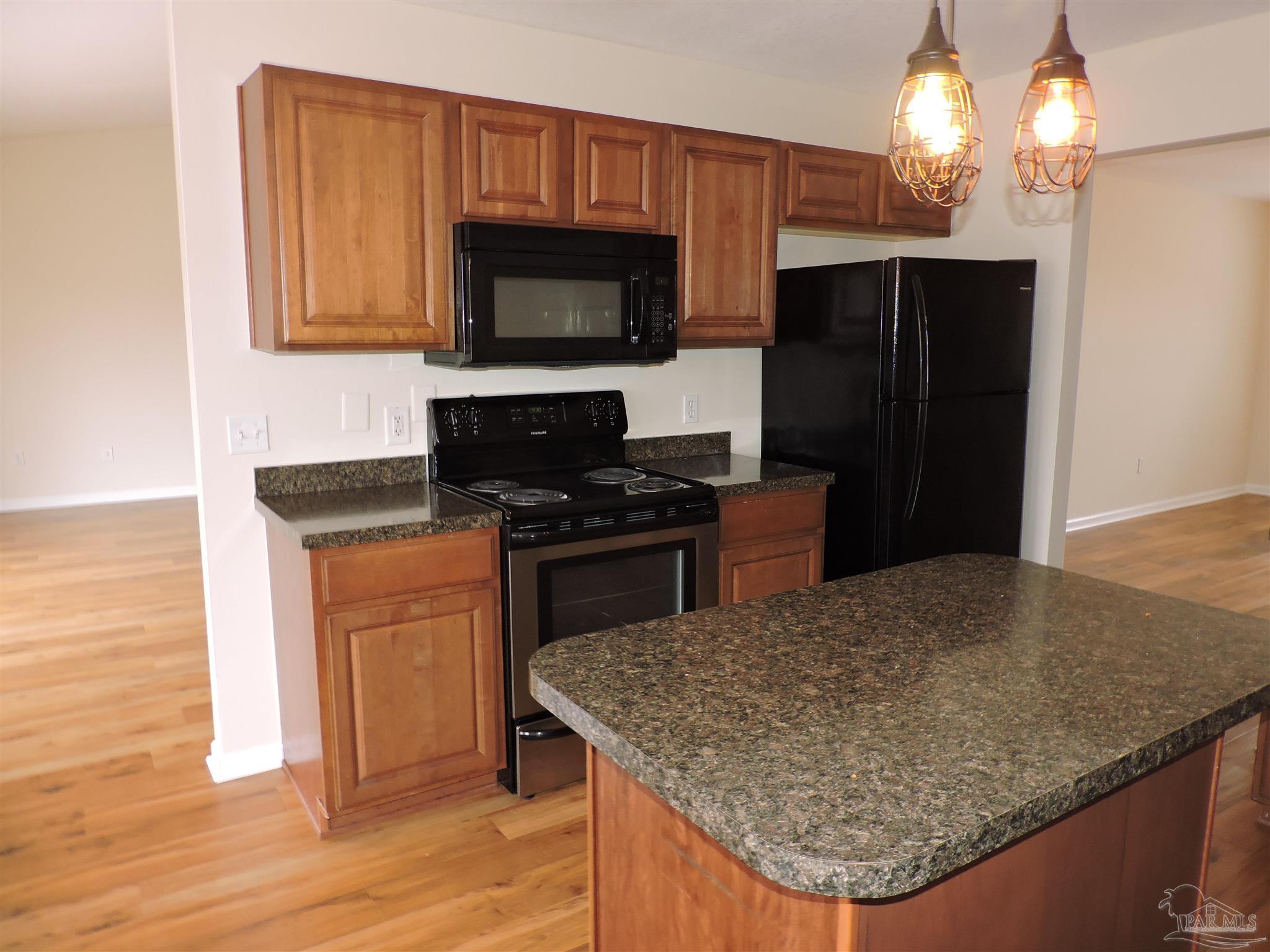 7070 Marissa Point Lane Milton, FL 32570 - Photo 6 of 21 a kitchen with stainless steel appliances granite countertop a sink a microwave a refrigerator and a stove