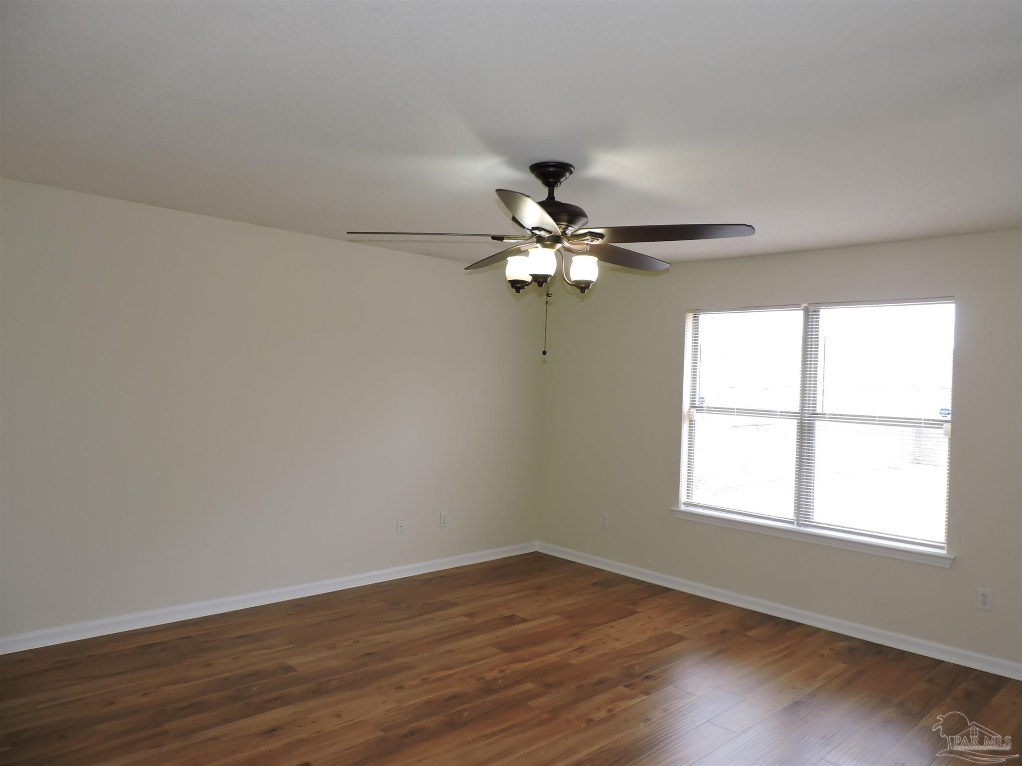 7070 Marissa Point Lane Milton, FL 32570 - Photo 9 of 21 a view of an empty room with wooden floor and a window