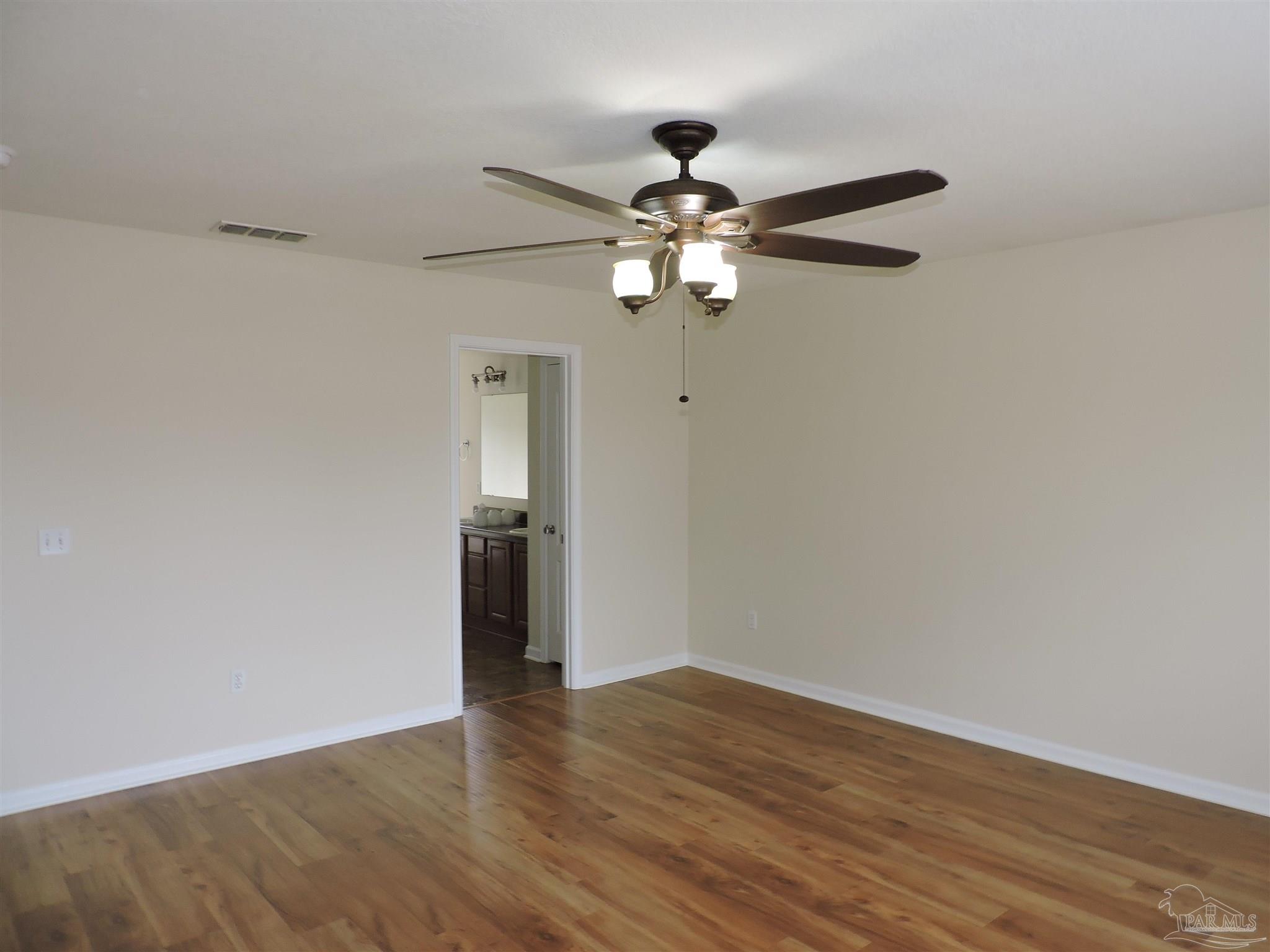 7070 Marissa Point Lane Milton, FL 32570 - Photo 10 of 21 a view of a room with wooden floor and a ceiling fan