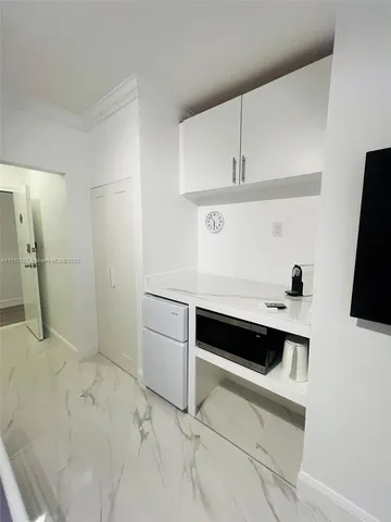 a view of cabinets and utility room with racks on the wall