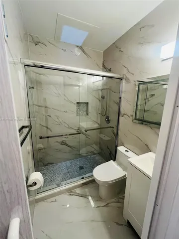 a bathroom with a toilet and a shower