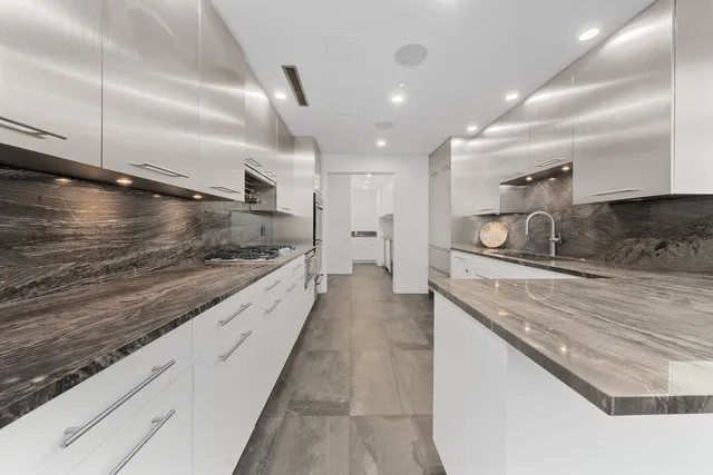 a kitchen with white cabinets and stainless steel appliances
