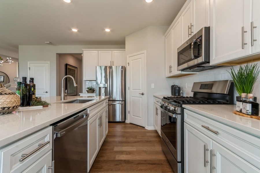 1233 Draper Road McHenry, IL 60050 - Photo 4 of 14 a kitchen with stainless steel appliances granite countertop a sink stove and refrigerator