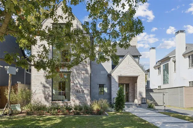 a front view of a house with a yard garage and tree