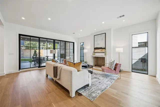 a living room with fireplace furniture and a large window