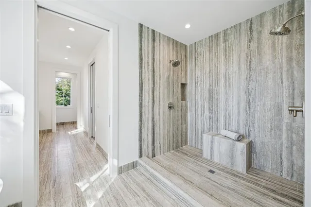 a view of a bathroom with shower glass door mirror and window