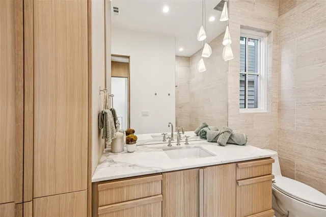 a bathroom with a sink vanity granite and toilet