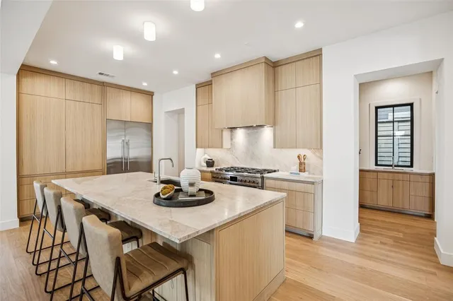 a kitchen with a stove a refrigerator and a dining table with wooden floor