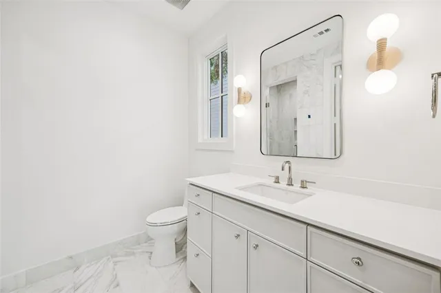 a bathroom with a sink a toilet and a mirror