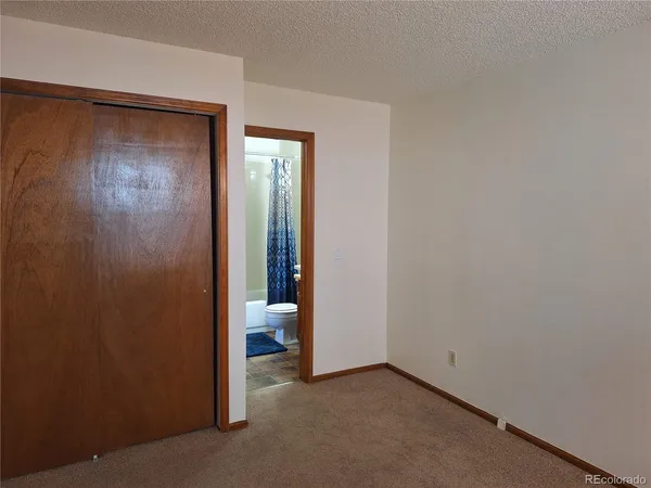 a view of a room with a ceiling fan and a walk in closet