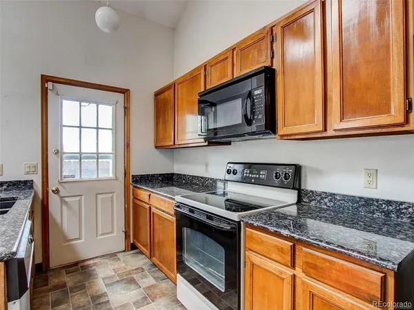 a kitchen with stainless steel appliances granite countertop a sink stove and cabinets