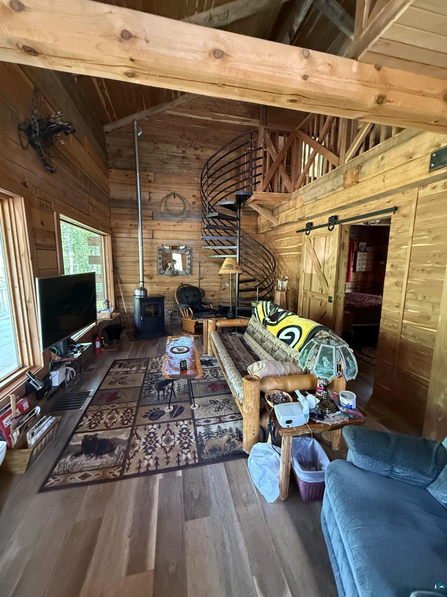 66795 Janecek Road Ashland, WI 54806 - Photo 7 of 10 Living room with wood walls, a wood stove, wood-type flooring, and wood ceiling