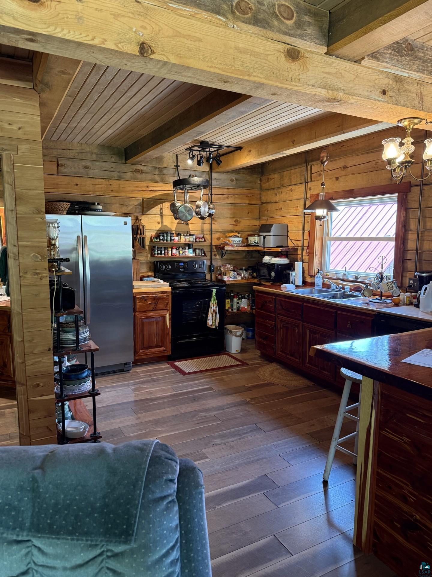 66795 Janecek Road Ashland, WI 54806 - Photo 10 of 10 Kitchen with black range with electric stovetop, wood walls, freestanding refrigerator, dark wood-type flooring, and a wood ceiling with exposed beams