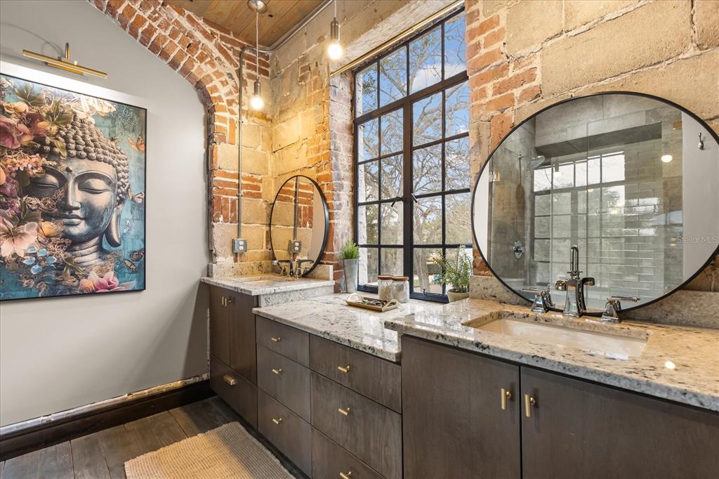 601 East Ridgewood Street Orlando, FL 32803 - Photo 42 of 86 a bathroom with a granite countertop sink a mirror and a shower