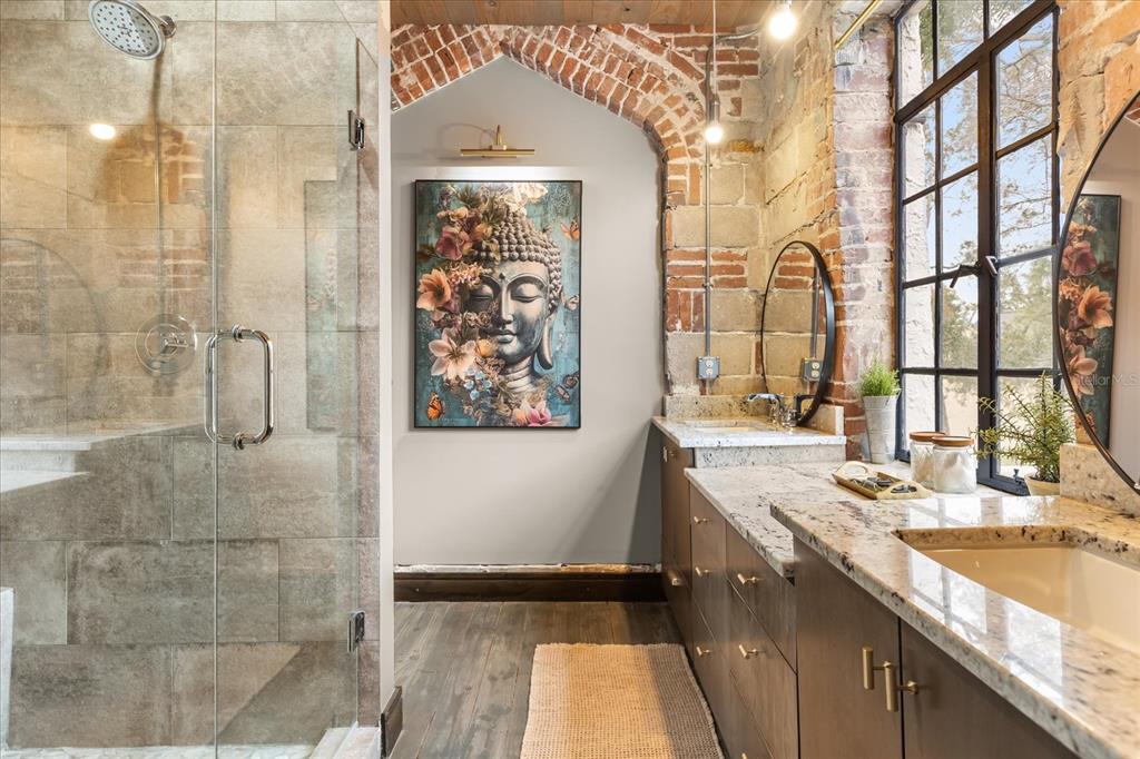 601 East Ridgewood Street Orlando, FL 32803 - Photo 45 of 86 a bathroom with a granite countertop sink a large mirror and shower