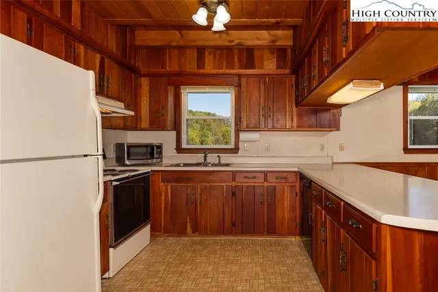 a kitchen with stainless steel appliances granite countertop a refrigerator a sink and a stove
