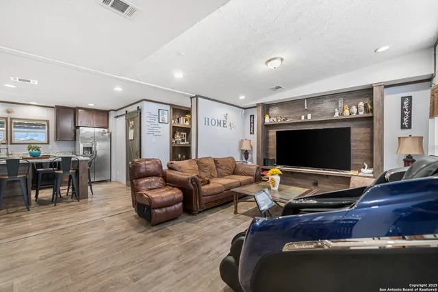 a living room with furniture floor and a flat screen tv