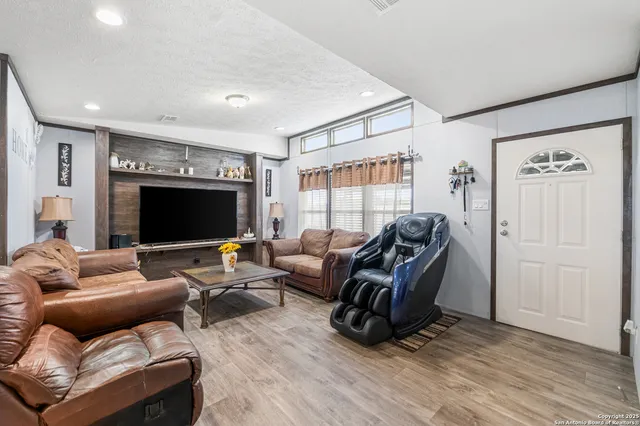 a kitchen with stainless steel appliances granite countertop a refrigerator a stove a sink a dining table and chairs