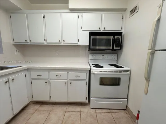 a kitchen with a sink window and cabinets