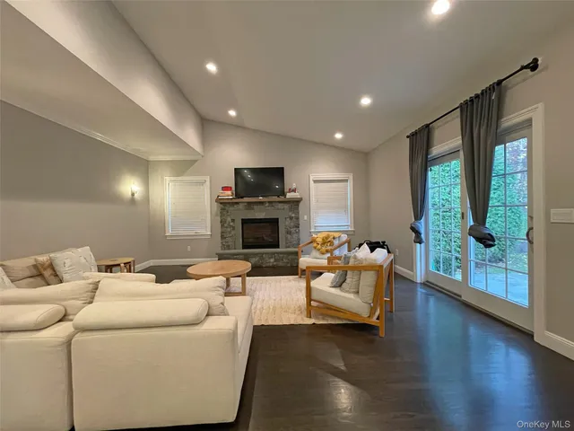 a living room with furniture fireplace and a large window