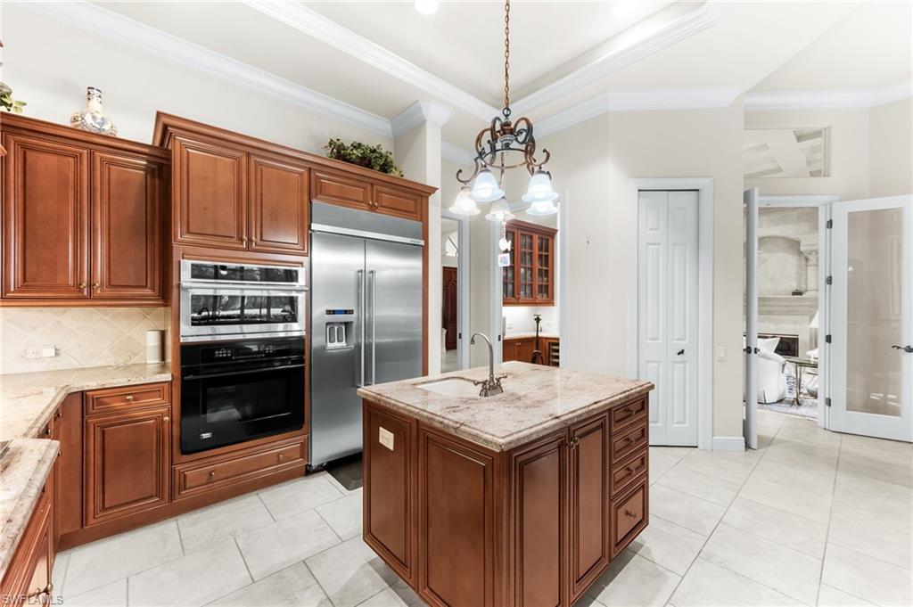 7615 Palmer Court Naples, FL 34113 - Photo 13 of 50 Kitchen with a kitchen island with sink, built in fridge, ornamental molding, a chandelier, and double wall oven
