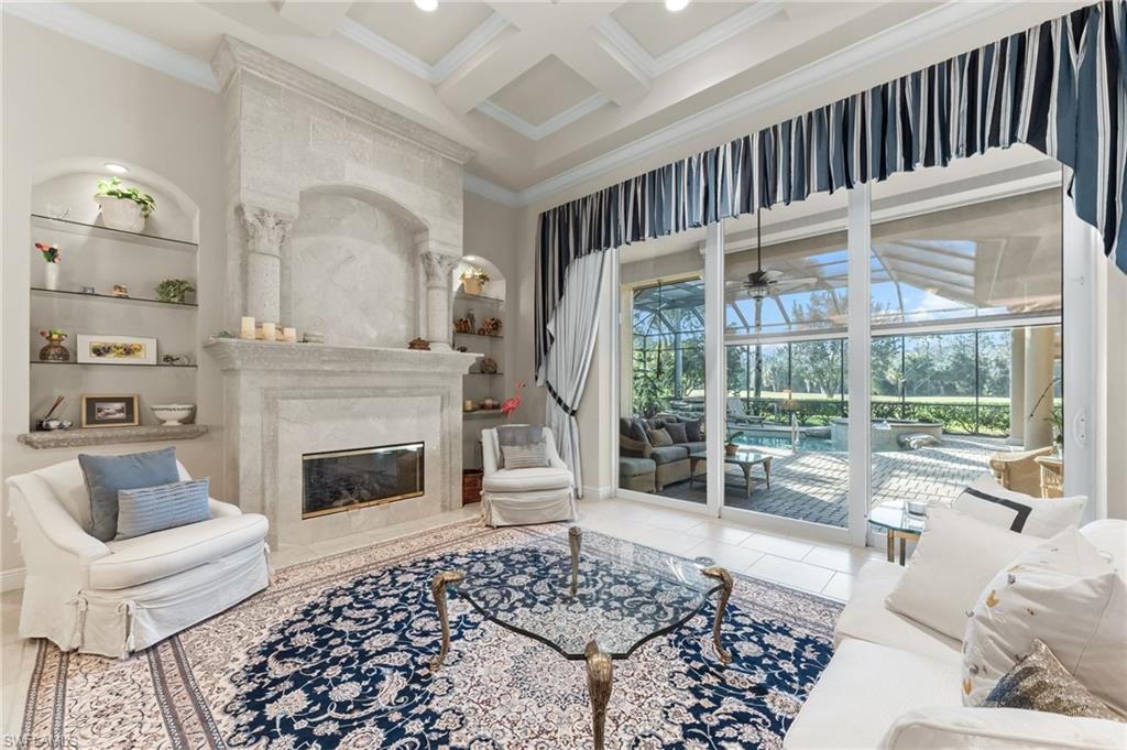 7615 Palmer Court Naples, FL 34113 - Photo 5 of 50 Living area featuring a sunroom, coffered ceiling, built in features, crown molding, and a ceiling fan