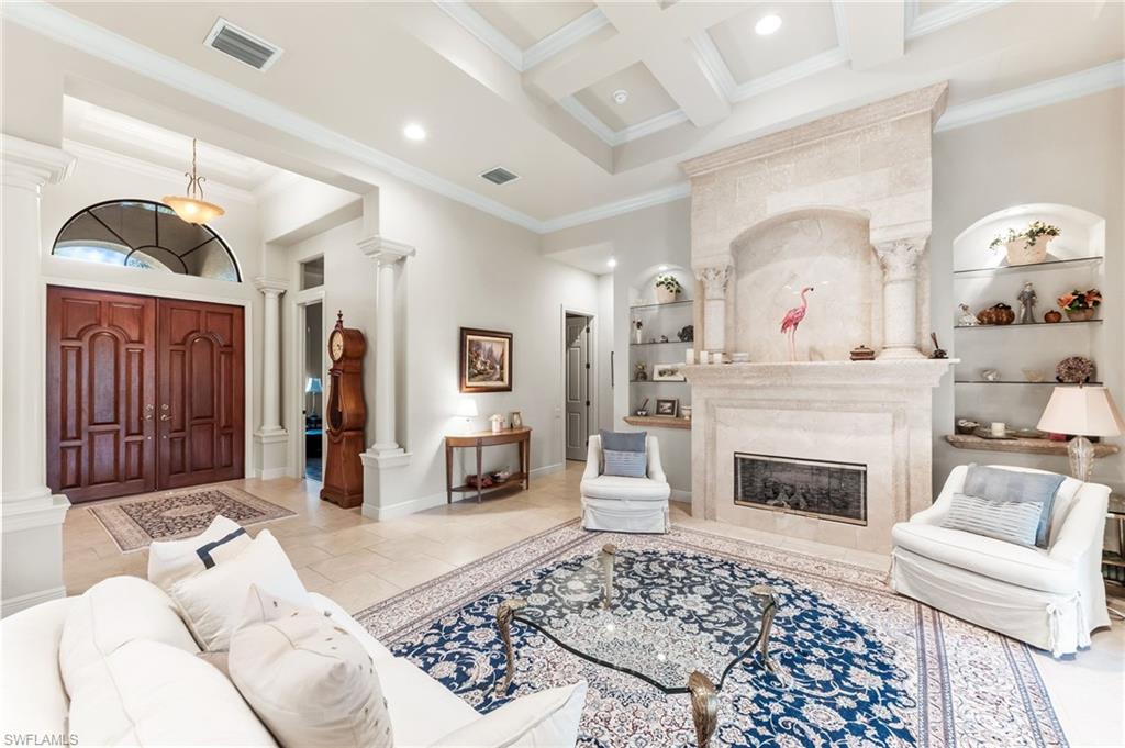7615 Palmer Court Naples, FL 34113 - Photo 8 of 50 Living room featuring coffered ceiling, crown molding, recessed lighting, a fireplace, and decorative columns