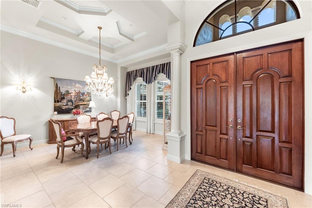 7615 Palmer Court Naples, FL 34113 - Photo 9 of 50 Entrance foyer featuring ornate columns, high coffered ceiling, ornamental molding, suspended lighting, and light tile patterned flooring