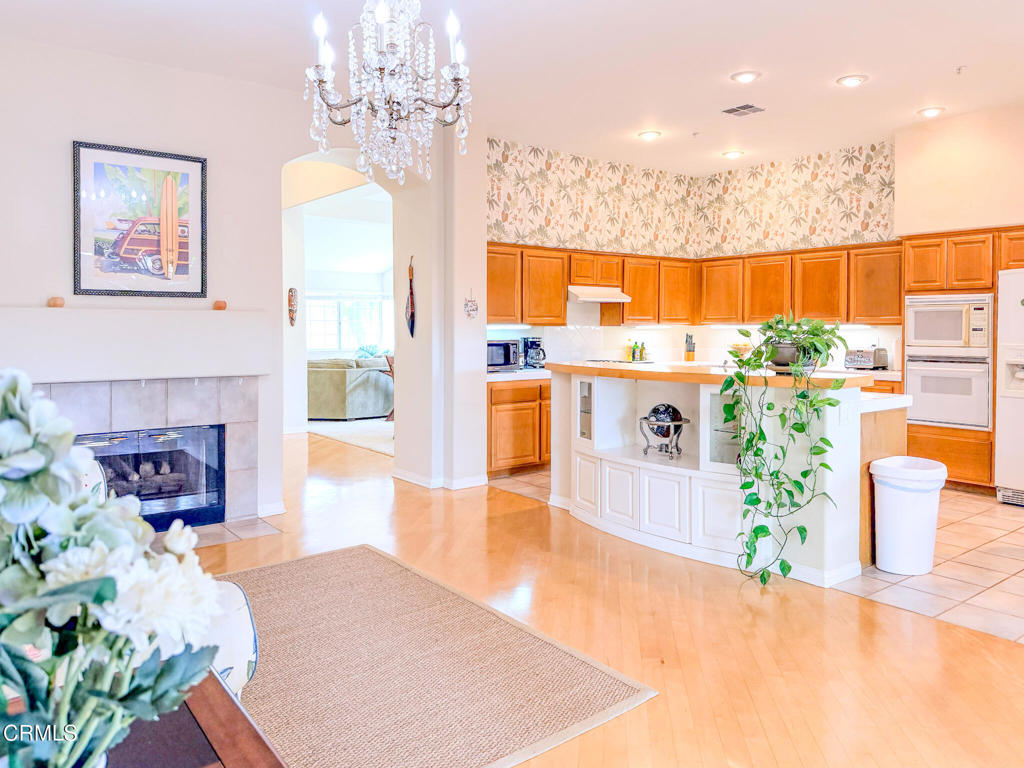2300 Bayhill Court Oxnard, CA 93036 - Photo 7 of 28 a living room with furniture a fireplace and a chandelier