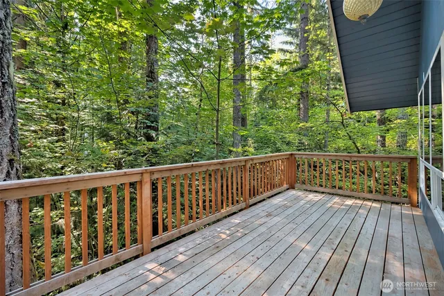 a balcony with wooden floor and trees in the back
