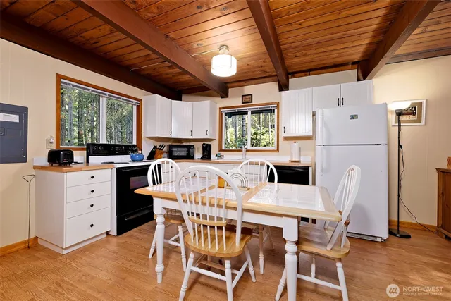 a open kitchen with a table chairs and a refrigerator