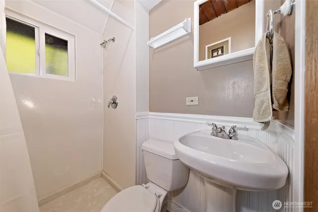 a bathroom with a sink toilet and mirror