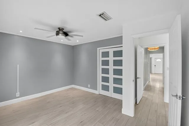 a view of an empty room with a window and wooden floor