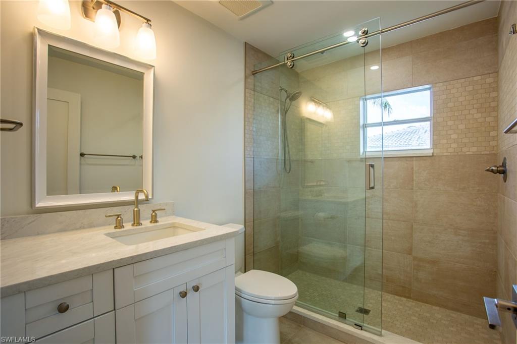 27682 Imperial River Road, Unit CH2 Bonita Springs, FL 34134 - Photo 12 of 26 a bathroom with a granite countertop sink a toilet a shower and a mirror