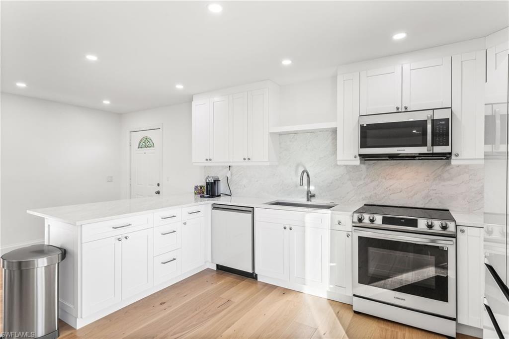 27682 Imperial River Road, Unit CH2 Bonita Springs, FL 34134 - Photo 6 of 26 a kitchen with stainless steel appliances a stove microwave and cabinets
