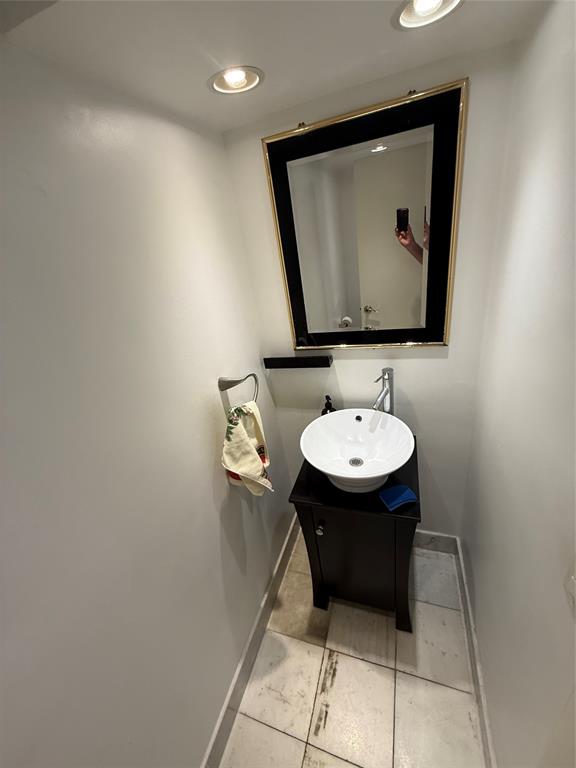 19428 Northeast 26th Avenue, Unit 103 Miami, FL 33180 - Photo 8 of 65 a bathroom with a sink a mirror and a toilet