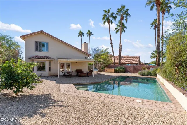 a view of a house with pool and sitting area