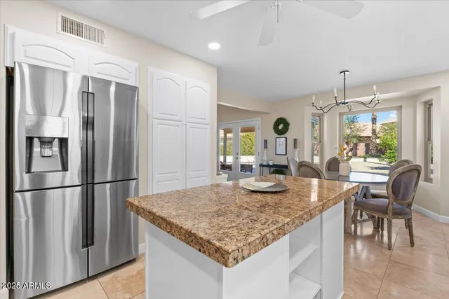 a kitchen with stainless steel appliances granite countertop furniture and a refrigerator