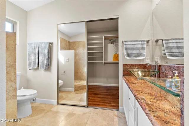 a bathroom with a granite countertop sink a toilet and shower