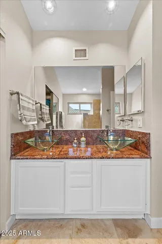 a bathroom with a granite countertop sink and a mirror