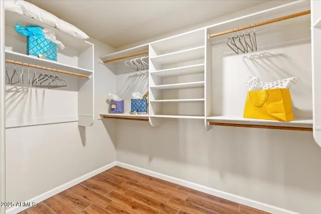 a view of walk in closet with window and wooden floor