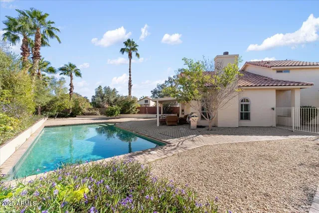 a view of a house with pool and sitting area