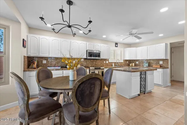 a kitchen with kitchen island a stove a table and chairs