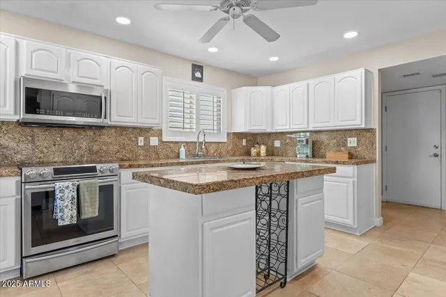 a kitchen with stainless steel appliances granite countertop a stove sink and microwave