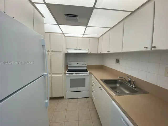 a kitchen with a stove sink and cabinets