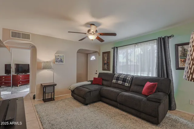 a living room with furniture a ceiling fan and a window