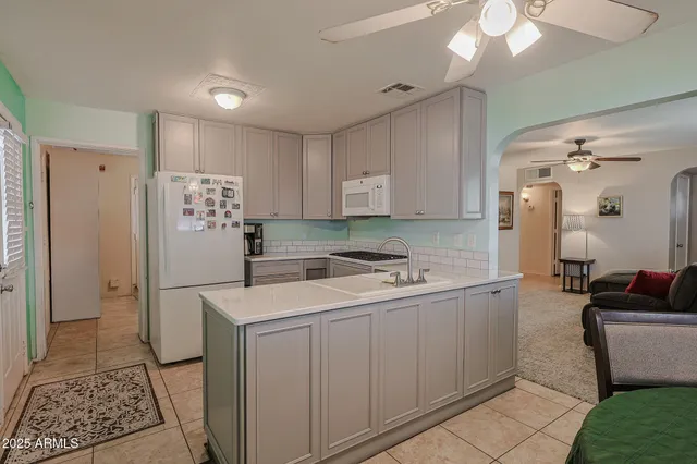 a kitchen with a sink a refrigerator and cabinets